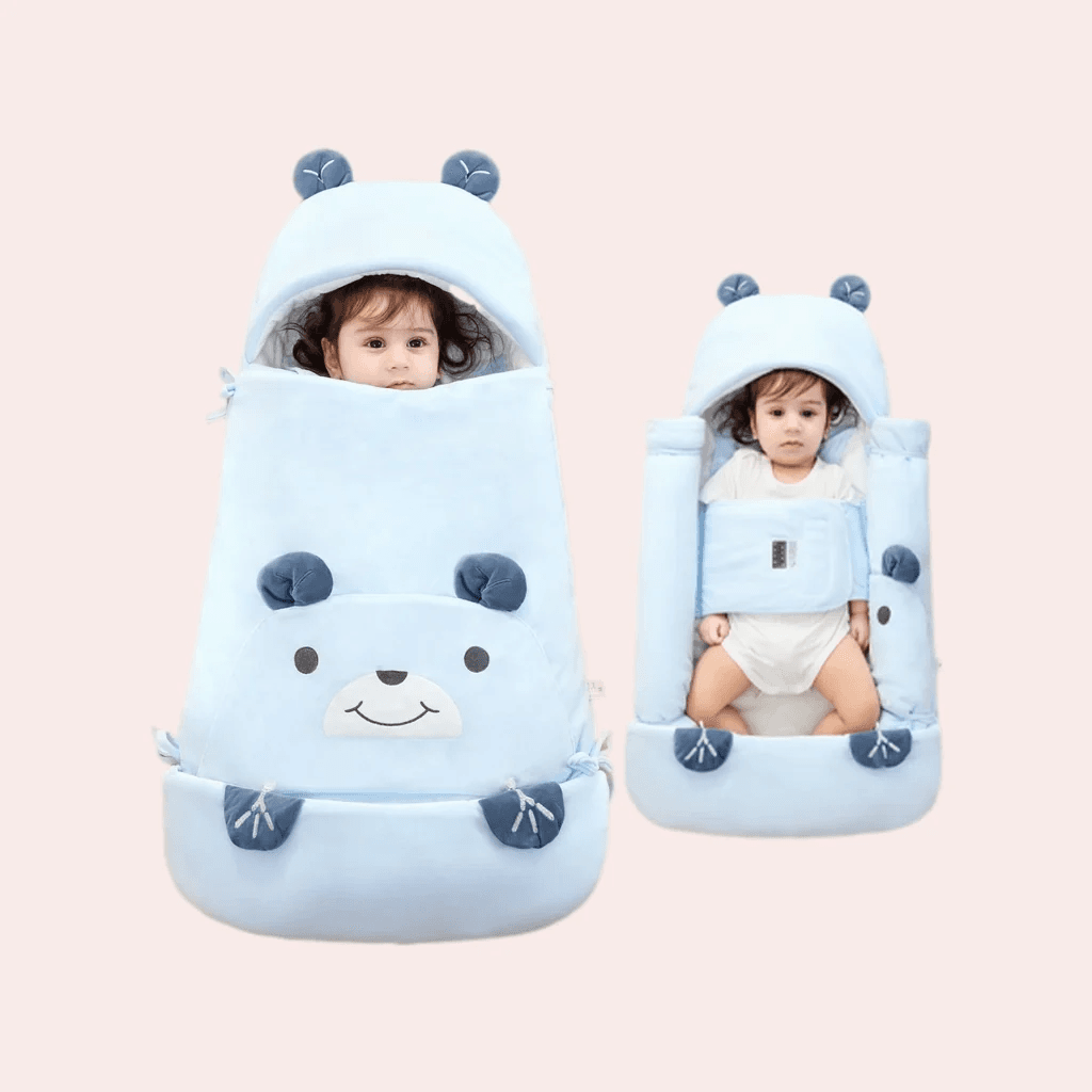 Light blue baby swaddle blanket with cute bear face details and 3D ears on the hood, shown fully wrapped and open around a baby.
