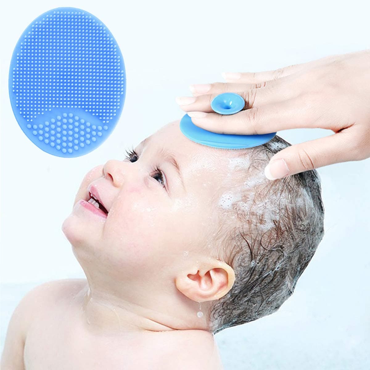 A person using a light blue silicone scrubber with tiny bristles to gently wash a baby's wet hair.